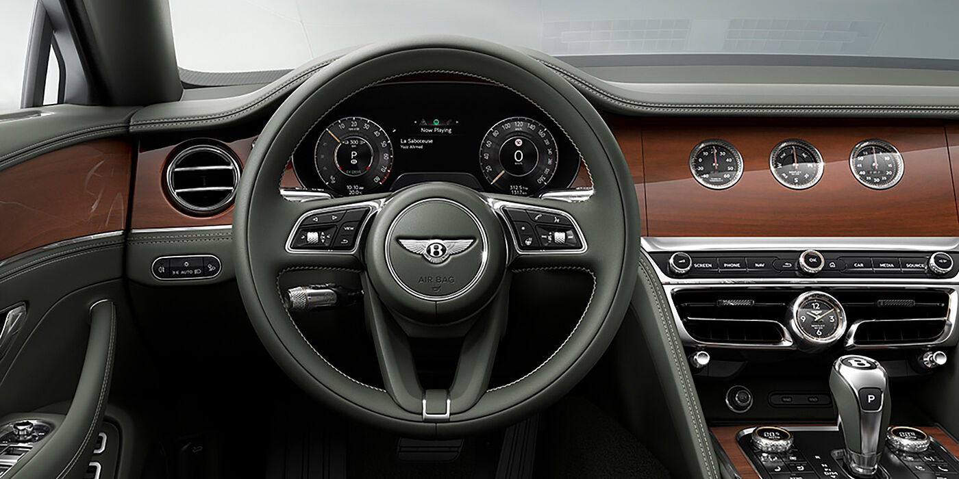 Bentley Monaco New Bentley Flying Spur sedan front cabin in Cumbrian Green hide and Crown Cut walnut veneer showing steering wheel and Rotating Display with three clocks on face