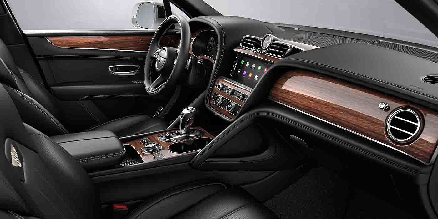 Bentley Monaco Bentley Bentayga EWB interior with a Crown Cut Walnut veneer, view from the passenger seat over looking the driver's seat.