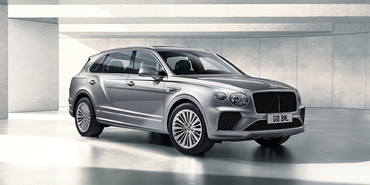 Bentley Monaco Bentley Bentayga Extended Wheelbase SUV front three quarter in Moonbeam paint with a grey background