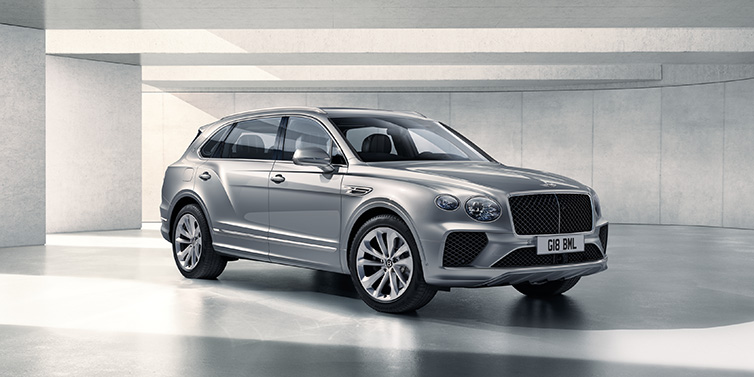 Bentley Monaco Bentley Bentayga Extended Wheelbase SUV front three quarter in Moonbeam paint with a grey background