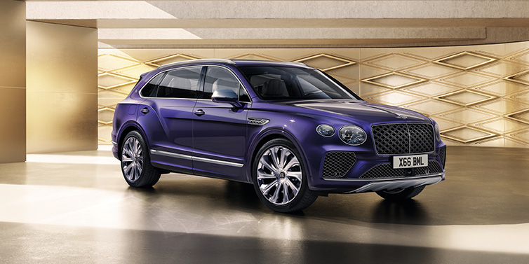 Bentley Monaco Bentley Bentayga Extended Wheelbase Mulliner SUV front three quarter in Tanzanite Purple paint with a gold patterned background