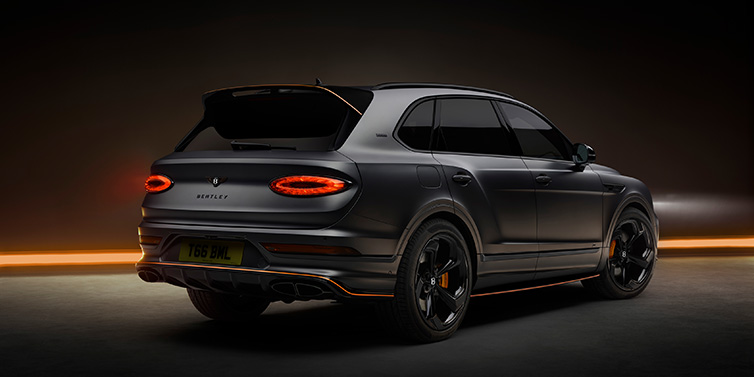 Bentley Monaco Bentley Bentayga S Black Edition SUV rear three quarter in Anthracite Satin paint against a dark red and yellow background