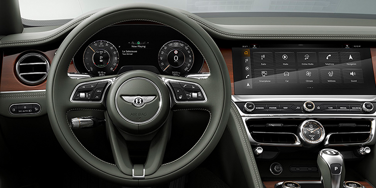Bentley Monaco New Bentley Flying Spur front cabin interior in Cumbrian green hide with Crown Cut walnut veneer showing steering wheel and driver controls