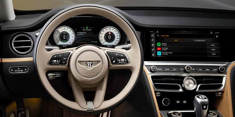 Bentley Monaco Bentley Flying Spur Mulliner sedan front interior detail of steering wheel and driver screens surrounded by Linen and Beluga black hides